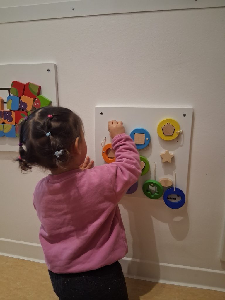 Kind spielt am Motorikbrett